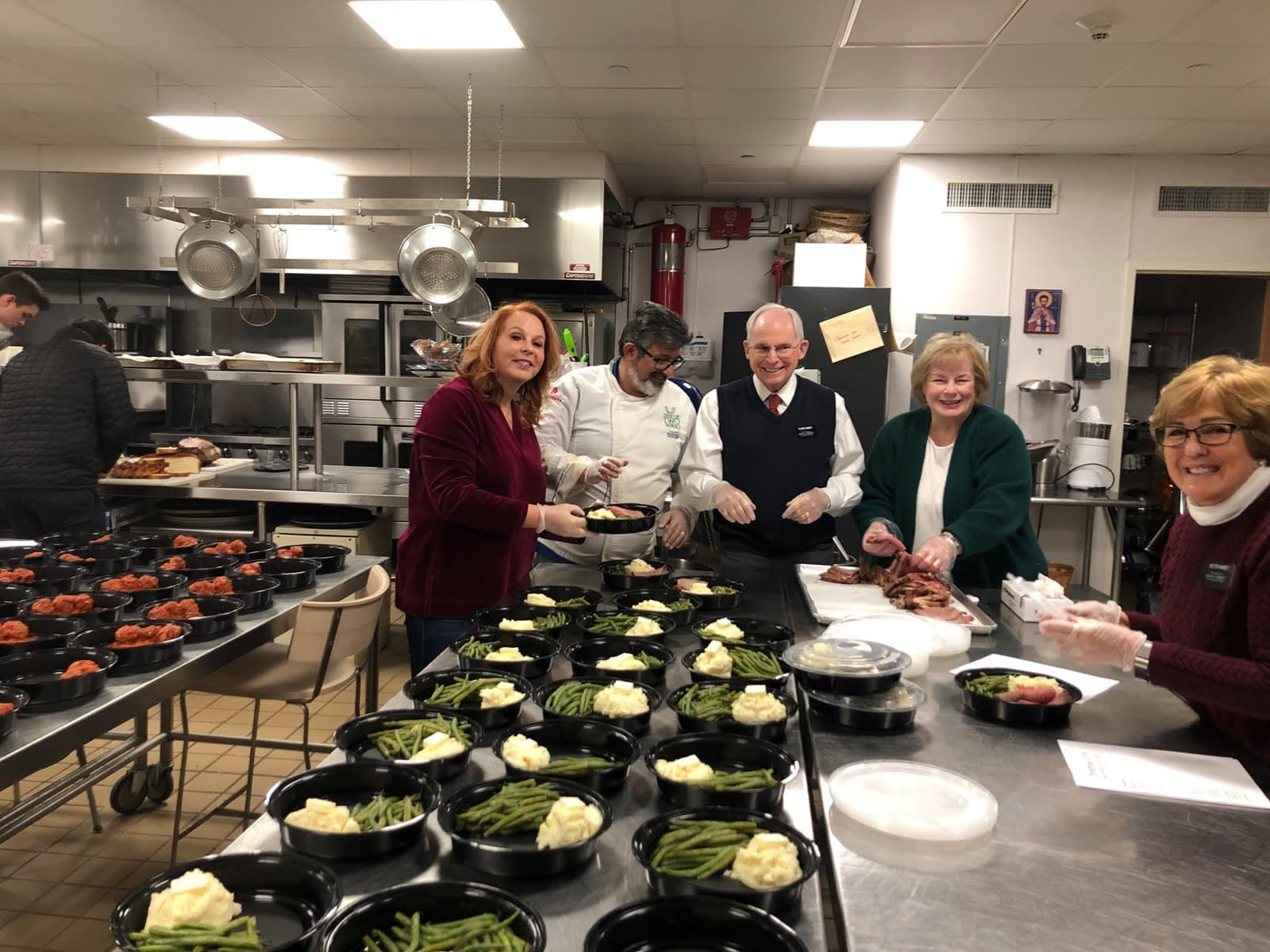 Citizens 4 Humanity volunteers and Chef Marco plating dozens of fresh meals in a community kitchen on the East End of Long Island.