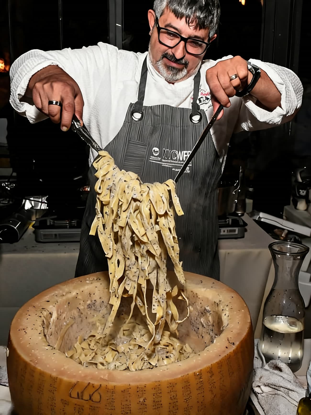 Master Chef Marco Barrila serving fresh truffle pasta from a parmesan wheel.